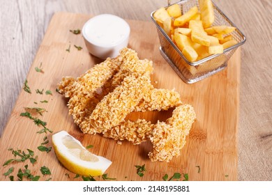 Corn Flakes Deep Fried Chicken Sticks Andfrench Fries, Served On Wooden Board