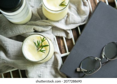 Corn Juice Smoothie On A White Sieve On The Side With Glasses, Book Prop Place On Wood Table. Top View