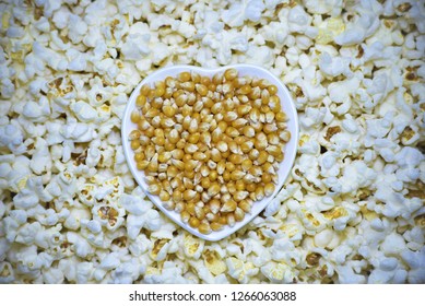 Corn kernels in the bowl of shape of heart with ready made popcorn around it. Cinema or valentine`s day icon. - Powered by Shutterstock