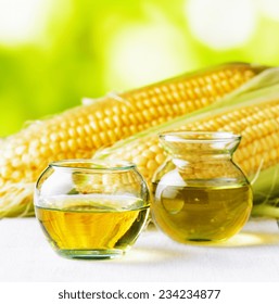 Corn oil and corn cobs on a garden table.