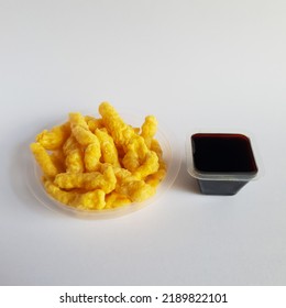 Corn Snack Placed In Round Container With Soy Sauce Isolated On White Background. Cheap Snacks.