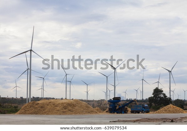  Corn sorting machine is working\
and Wind power generators in the field against blue\
sky