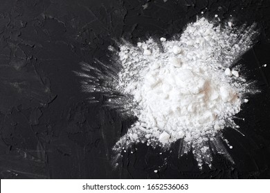 Corn starch on a black background, top view, copy space. Corn white starch on a black table. Potato starch on a black background. Top view, copy space.