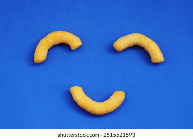 corn sticks, snack, smiley face, blue background, fun food, playful snack, food art, corn puffs, creative snack, happy face, food design, minimalistic, kids snack, bright background, cheerful, fun wit - Powered by Shutterstock