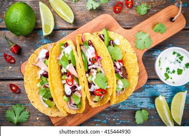 corn tacos with pork and vegetables on a wooden table. top view