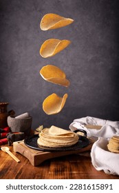 Tortillas de maíz a la plancha mexicana en un marco típico de la cocina mexicana, con una rústica mesa de madera y molquetes de piedra.
