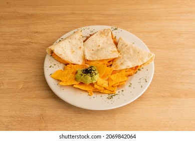 A Corn Or Wheat Tortilla, Folded In Half That Can Be Filled With Cheese, Beans And Chicken And Eaten Hot, Either Fried Or Cooked On The Comal With Corn Chips And Melted Cheddar Cheese