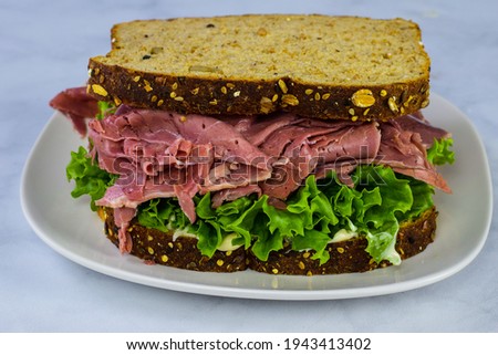 cornbeef  on top of lettuce and mayonnaise between whole wheat bread