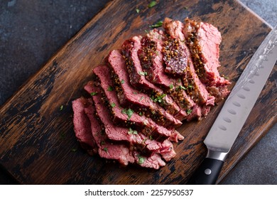 Corned beef cooked and sliced on a cutting board, irish recipe idea for St Patricks day