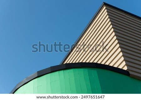 corner of a building with rounded and geometric elements on a blue sky