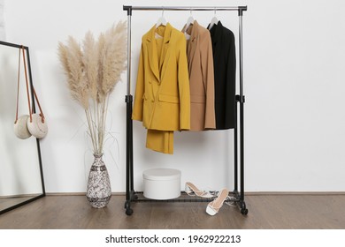 Corner in fashion atelier with fashionable tailored blazers hanging on a rack. Modern premium quality hand made woman's fashion.