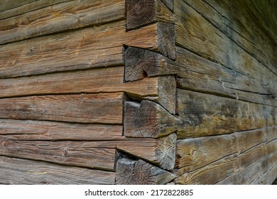 The corner of a house made of wooden logs, the corner joint of a chopped log house.Rustic log cabin wood building structure homestead historic site texture background .