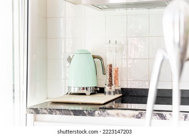 Corner Of A Kitchen With Small Appliances On A Black Marble Countertop