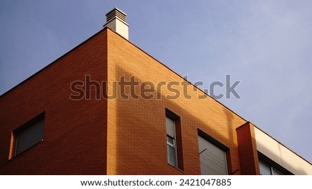corner of modern red brick building facade against sky