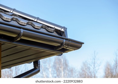 Corner Of The New Modern House With Roof, Gutter And Wooden Shutter Under Blue Sky