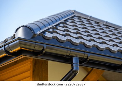 Corner Of The New Modern House With Roof, Gutter And Wooden Shutter Under Blue Sky