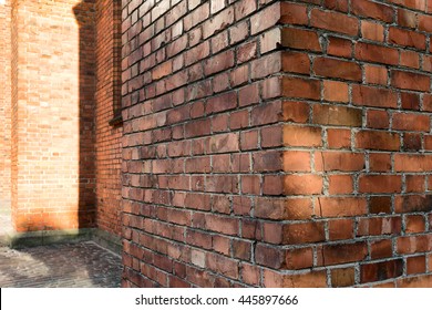 Corner Of Old House With Cracked Red Brick Building With A View On The Street 