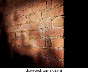 corner of red brick wall in shadow