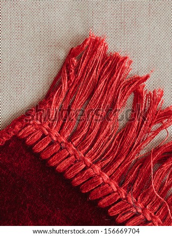 Corner of a red rug showing tassles