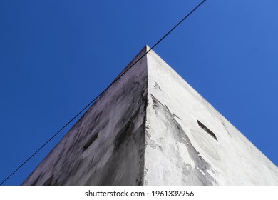 Corner view of cement wall surface square building with clear blue sky background