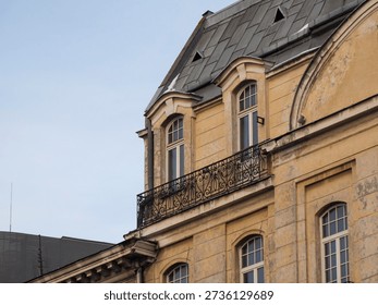 Corner view of a classical yellow building facade with ornate architectural details