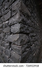 Corner View Of A Dark Stone Wall House.