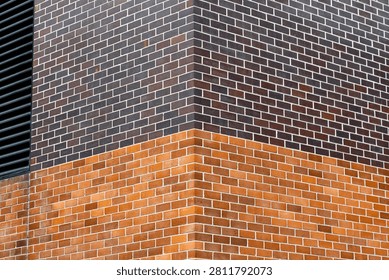 Corner view of two different colors of brick wall.