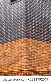Corner view of two different colors of brick wall.