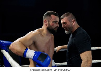 Cornered boxer receives strategic advice from trainer during intense bout. - Powered by Shutterstock