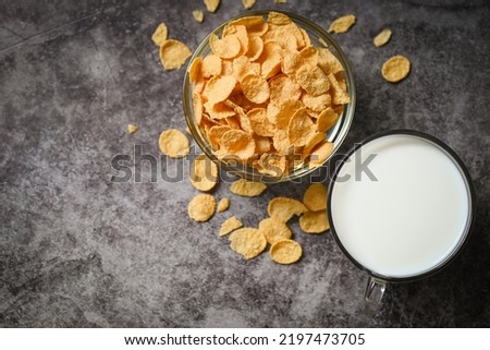 cornflakes bowl breakfast food and snack for healthy food concept, morning breakfast fresh whole grain cereal, cornflakes with milk on dark background - top view