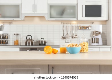 Cornflakes with glasses of juice and milk on kitchen table - Powered by Shutterstock