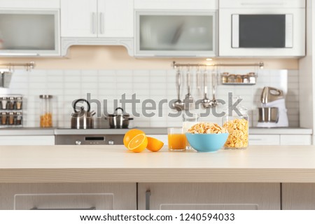 Cornflakes with glasses of juice and milk on kitchen table