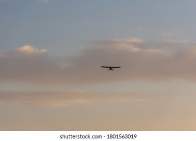 The Cornhusker Plane Is High In The Sky. Fly-around On A Small Plane. Sunset Sky With Clouds And A Plane.