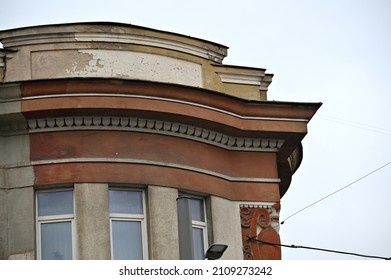 the cornice of the old building is decorated with a parapet