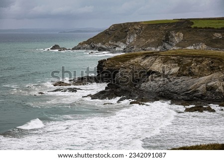 The Cornish coast on a cloudy day with waves.