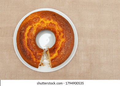 Cornmeal Cake (Bolo De Fuba) Cut Brazilian Style On A White Plate. Isolated On Jute. Top View. Copy Space. Horizontal Shot.