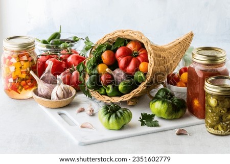 A cornucopia filled with garden vegetables and surrounded by preserves.