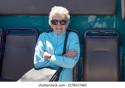 Cornwall, England, UK. 2022.  Holidaymaker Travelling On The Top Deck Of A Public Service Bus Smiling And Using A Pensioners Bus Pass. Cornwall, UK