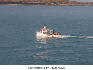 Cornwall, UK - 12th April 2016:Fishing Boat Returns To Harbour After A Day Fishing.  The Trawler Has Buoys Along The Side.  There Is A Bow Wave And Wake From The Boat.