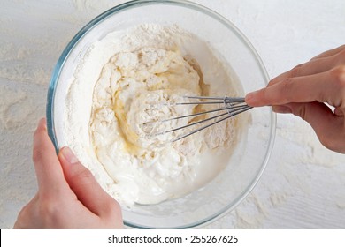 Corolla And Broken Eggs With Flour Mixing In Bowl