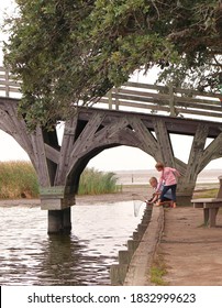 Corolla, NC/USA-September 22 2020: Children Crabbing With Net Under A Wooden Bridge Arch