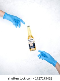 Corona Beer With Two Blue Protective Gloves Like The Creation Of Adam Concept