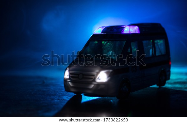 Corona virus concept with Ambulance car. Stay home\
for precautionary measures to prevent from corona virus. Ambulance\
car on dark misty background. Creative artwork decoration.\
Selective focus