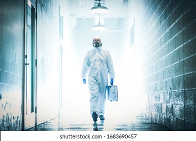 corona virus concept. male scientist doctor in latex biochemical protective suit walking in laboratory coridor holding analysis case with biohazard sign