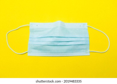 corona virus covid 19 surgical mask
lay flat on a yellow background - Shutterstock ID 2019483335