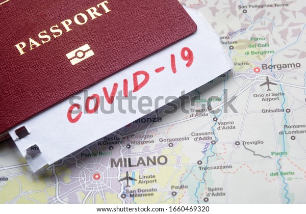 Corona virus and tourism in Italy, Europe. COVID-19\
note and tourist passport on map with Milan. Medical test at border\
control due to coronavirus. Concept of travel restrictions in Italy\
and EU.