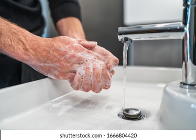 Corona virus travel prevention man showing hand hygiene washing hands with soap in hot water for coronavirus germs spreading protection.