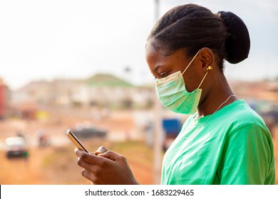 Corona Virus. Young Black African Lady Wearing Face Mask  Checking Social Media . African Girl Learning More On How To Prevent Virus