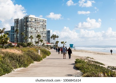 CORONADO, CALIFORNIA - JANUARY 20, 2018:  People Enjoy A Walk Along Coronado Central Beach In San Diego County, A 1.5-mile Long, Wide Sandy Beach Near The Hotel Del Coronado And Skyscraper Condos.