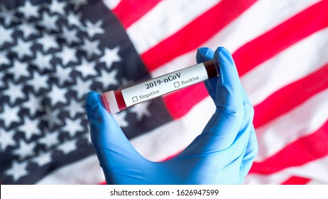 Coronavirus 2019-nCoV Outbreak In USA Concept. Nurse Hand In Gloves Holding Test Tube With Blood Over Flag Of The United States Of America. Blood Test For Novel Chinese Coronavirus